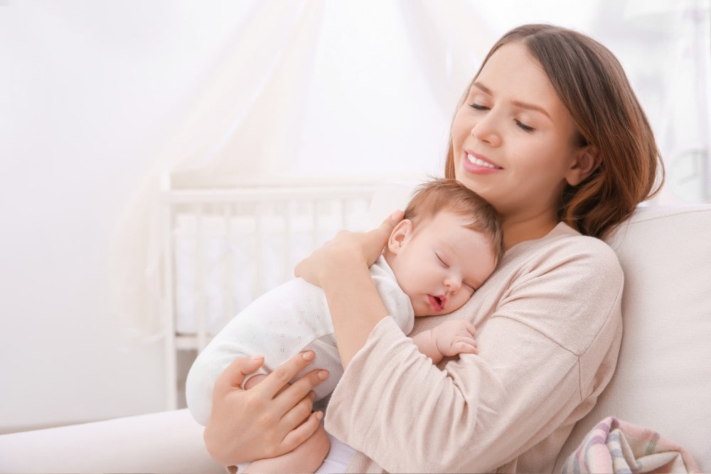 Young Mother Holding Sleeping Baby